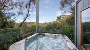 A hot tub with a glass barrier, surrounded by lush greenery and a clear sky. - Pet Friendly - Hopewell House with Spa and Golf Course Views (St Andrews Beach)