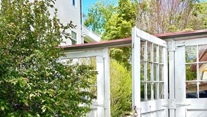 A white wooden gate with a metal latch, a gravel path, and a green bush. - Newly Updated! Private Pool! Walk to Beach, Shops, Restaurants & Train to Salem! (Rockport)
