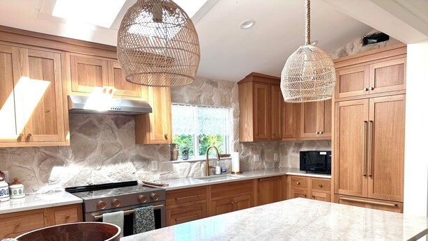 A modern kitchen with wooden cabinets, a large island, a stove, and hanging wicker light fixtures. - Newly Updated! Private Pool! Walk to Beach, Shops, Restaurants & Train to Salem! (Rockport)