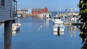 A harbor with boats docked, a red building, and a house with a window. - Newly Updated! Private Pool! Walk to Beach, Shops, Restaurants & Train to Salem! (Rockport)