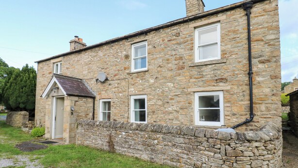 A stone building with a door, windows, and a chimney. - Rosemary Cottage (Leyburn)