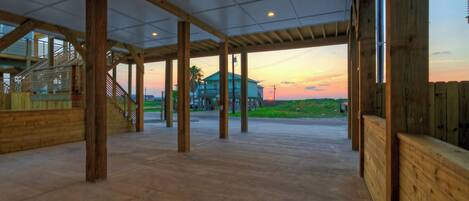 Amplio espacio interior con vista a una casa y al atardecer.