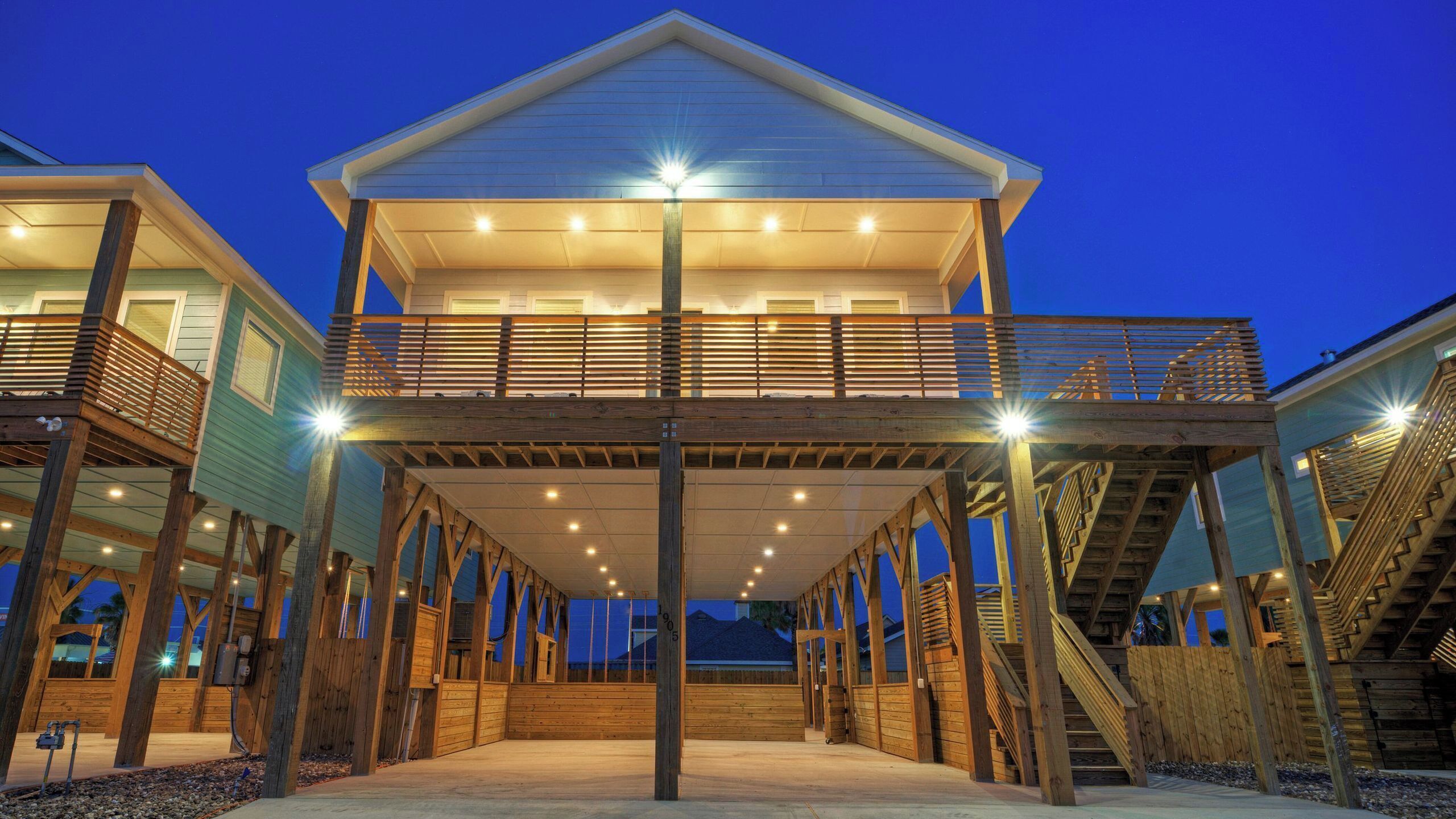 A two-story wooden structure with a balcony, multiple staircases, and a covered walkway.
