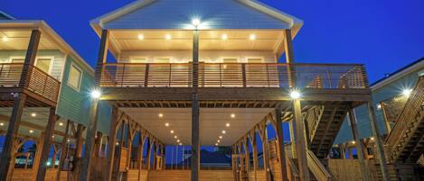 A two-story wooden structure with a balcony, multiple staircases, and a covered walkway.