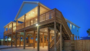 Una casa de dos pisos con un balcón de madera y escaleras.