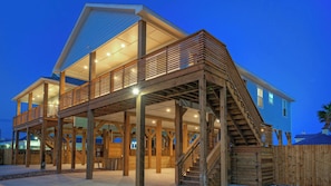 A two-story house with a wooden deck and stairs.