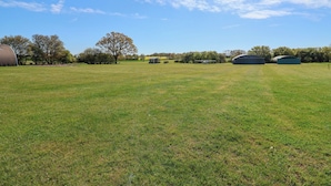 A grassy field with buildings and trees. - A-frame (Woodbridge)