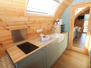 A compact kitchen with a built-in stove, a sink, and a small window above the countertop.