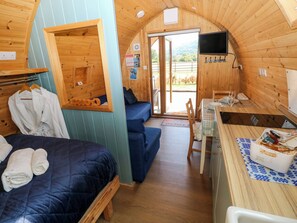 A cozy cabin with a bed, a sofa, a dining table, and a TV. - Bwthyn Bach Brefi (Tregaron)