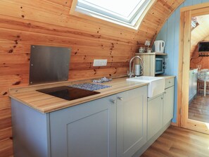 A compact kitchen with a wooden countertop, a built-in sink, and a small window above the sink. - Ty Twt Teifi (Tregaron)