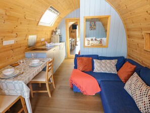 A cozy interior with a dining area, a sofa, and a kitchen. - Ty Twt Teifi (Tregaron)