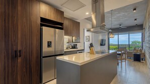 Une cuisine moderne avec des meubles en bois, des appareils en acier inoxydable et un îlot central.