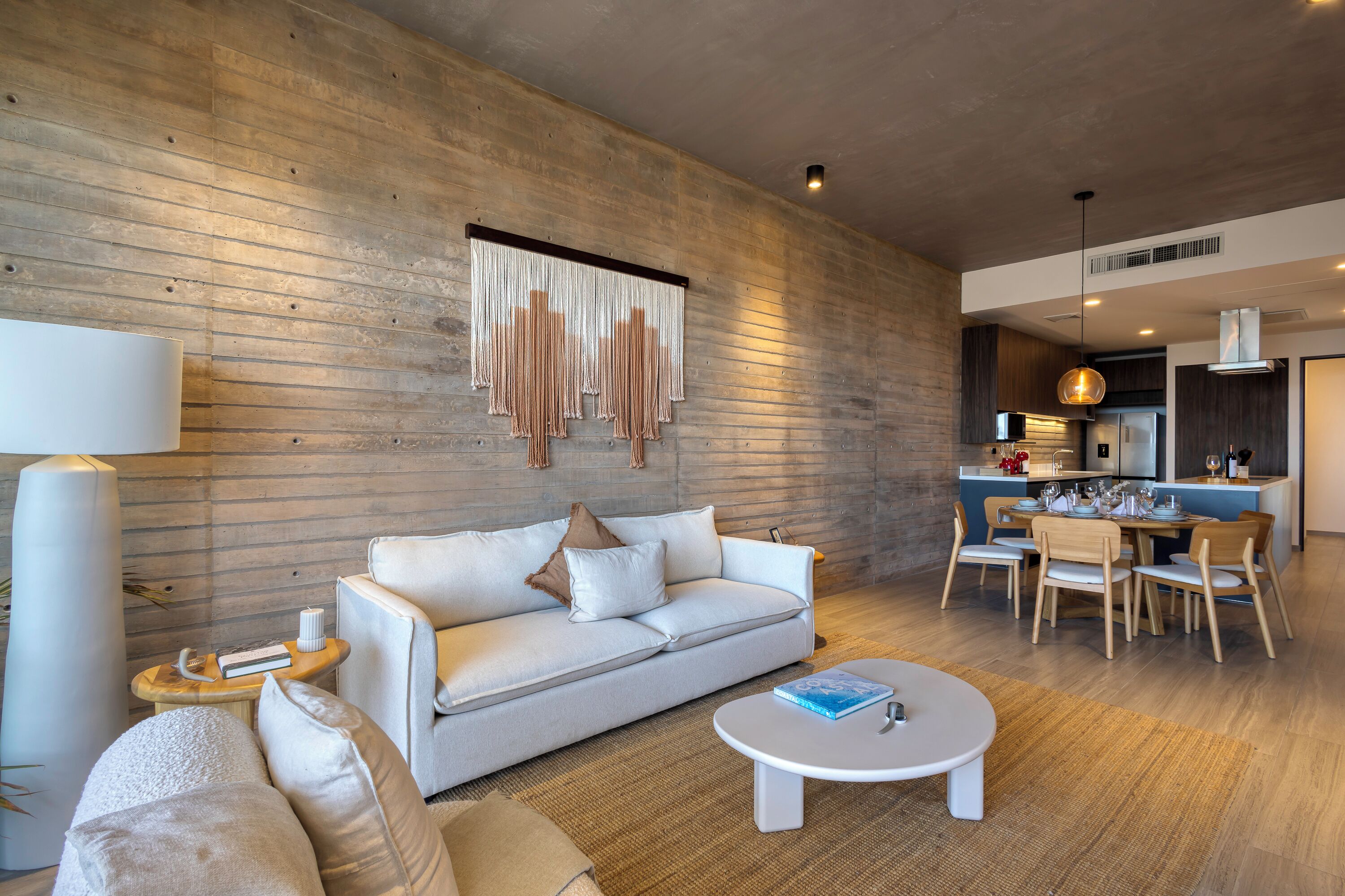 Una sala de estar moderna con sofá, mesa de centro y comedor.