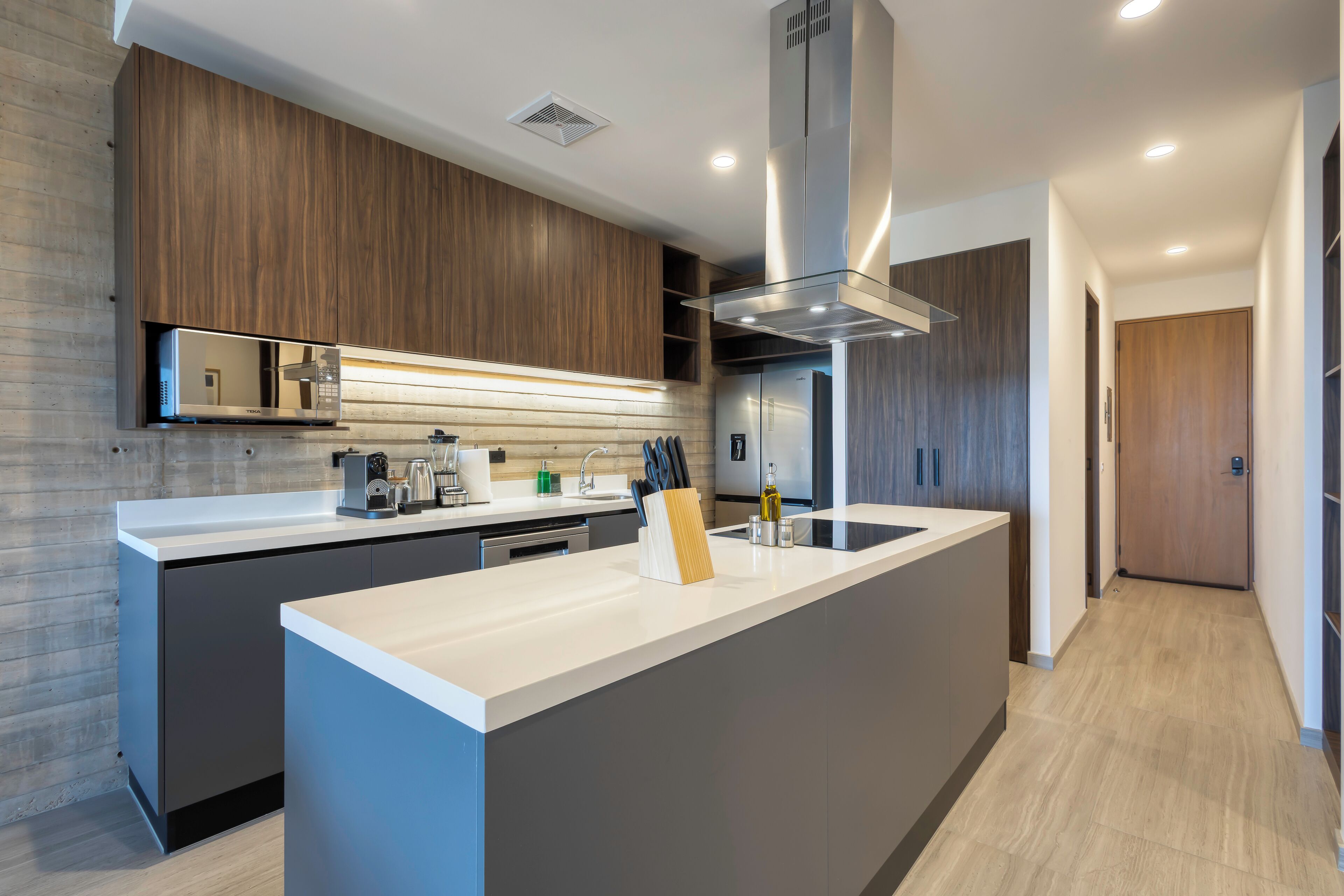 Une cuisine moderne dotée d’un îlot central, d’appareils électroménagers intégrés et d’un design épuré.