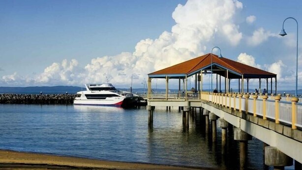 A pier with a covered walkway and a boat docked at the end. - "Salt-Air Serenity" (Redcliffe)