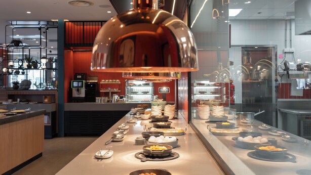 A buffet setup with various food items and utensils.