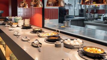 A buffet setup with various food items and utensils.