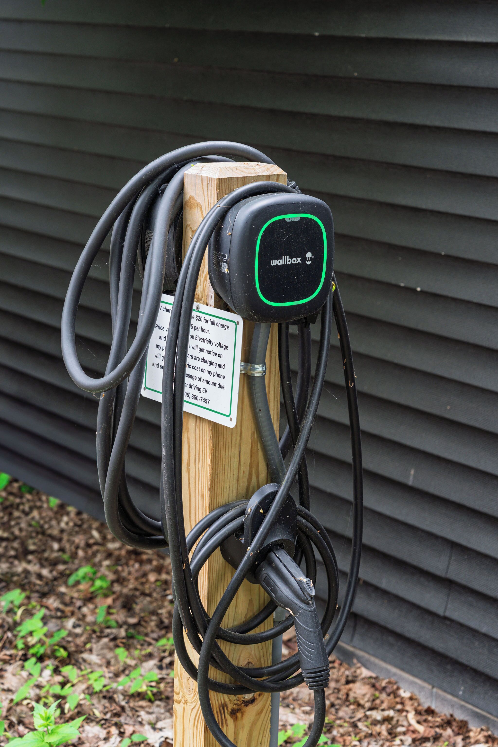 Une borne de recharge avec un panneau indiquant un coût de 20 $ pour une recharge complète et un tarif de 5 $ de l’heure pour l’électricité.