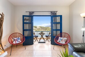 An open balcony with a view of the landscape, two red chairs, a table, and a sofa. - Famara Views III by Escape Home (Famara)