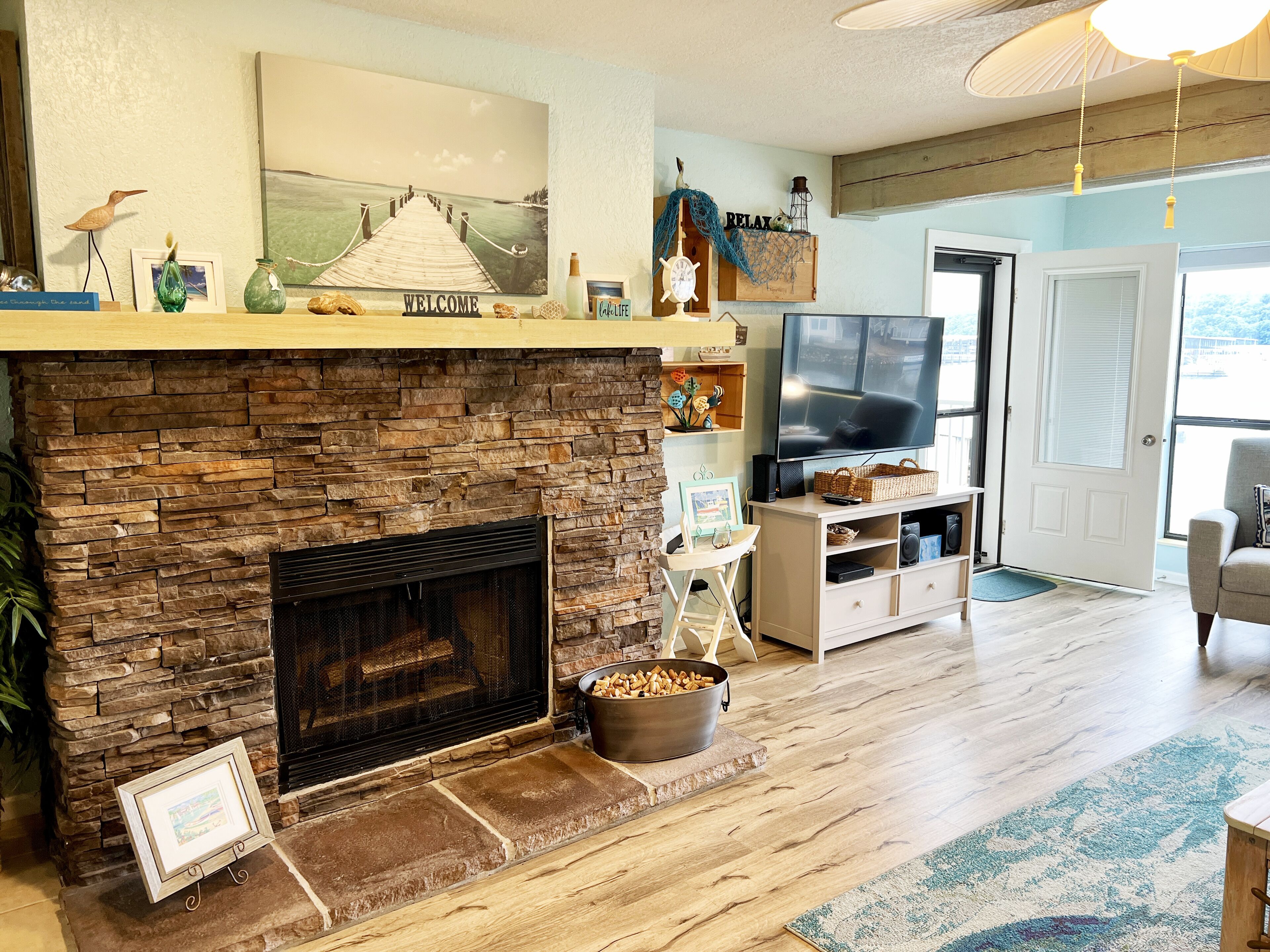 A living room with a stone fireplace, a television, and a cozy seating area.