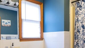 A bathroom with a wooden vanity, a white toilet, and a window with blinds. - Twin Falls Cabin Top Duplex (Spruce Pine)