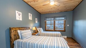 Une chambre avec deux lits, un plafond en bois et une fenêtre donnant sur un beau paysage.