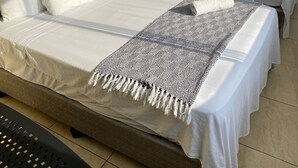 Een hotelkamer met twee bedden, een tafeltje en een stoel.