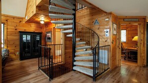 A wooden interior with a spiral staircase, a door with a glass panel, and a sign that reads 'It's a Wonderful Life.'