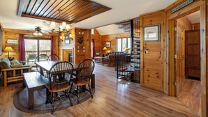 A wooden interior with a dining area, staircase, and a sign that reads 'It's a Wonderful Life.'