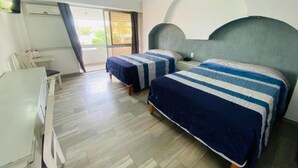 Habitación de hotel con dos camas, un escritorio y una silla.