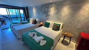 Quarto de hotel moderno com duas camas, uma janela grande e vista para o exterior.