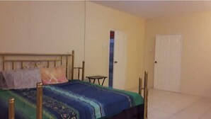 A bedroom with a bed, a small table, and a wardrobe.