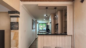A modern kitchen with a wooden island, two bar stools, and pendant lighting. - Charming 3-bedroom villa with WiFi, AC in the Air Sanih, The north of Bali (Bali)