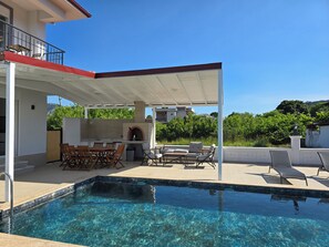 A swimming pool with a covered patio area, outdoor seating, and a brick oven. - Dalyan Villa AyDa (Dalyan)