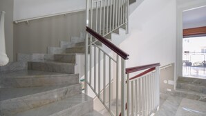 Eine Treppe mit Marmorstufen und weißen Geländern.
