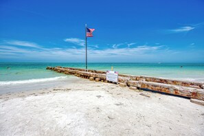Een strand met een houten pier en een Amerikaanse vlag.