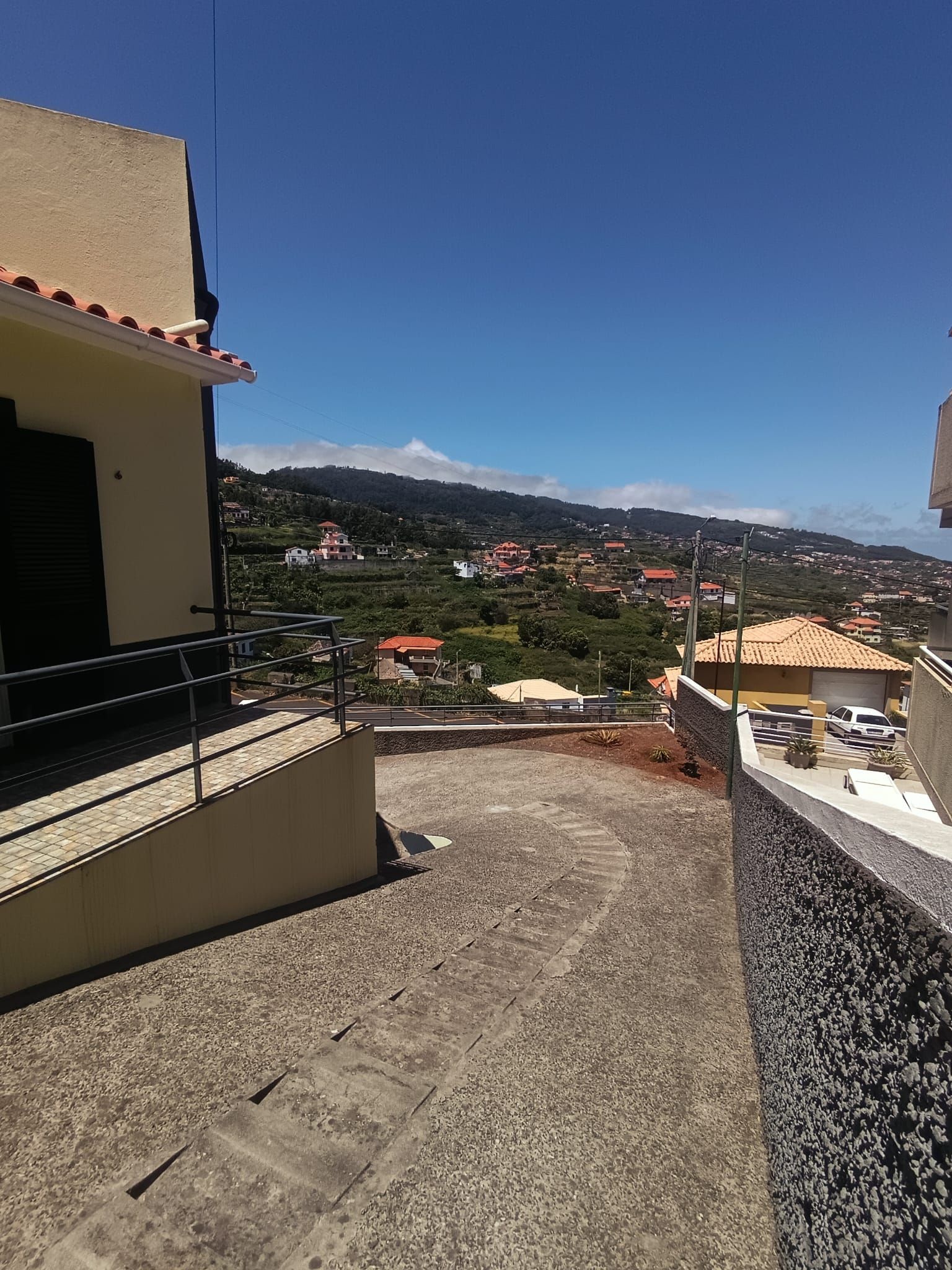 A balcony with a view of a hillside town.