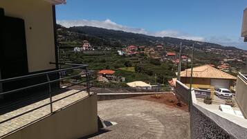 A balcony with a view of a hillside town.