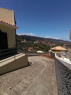 A balcony with a view of a hillside town.