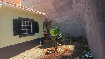 Ein Wohngebiet mit einem Haus, einer Betonmauer und einem Garten mit Pflanzen und Mulch.