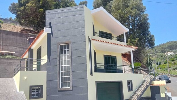 A modern two-story house with a grey facade, a green garage door, and a balcony. - Dotty's House (Santa cruz)