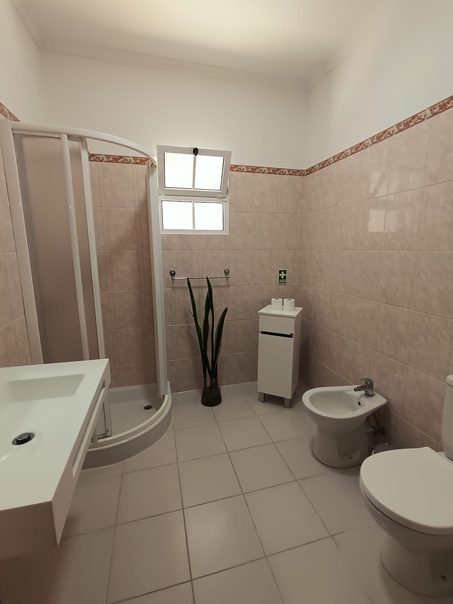 Ein Badezimmer mit Badewanne, Toilette, Bidet und einem kleinen Waschbecken.