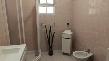 Ein Badezimmer mit Badewanne, Toilette, Bidet und einem kleinen Waschbecken.