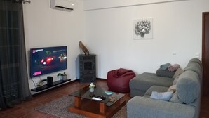 Un salon équipé d’un téléviseur à écran plat, d’une cheminée, d’un canapé et d’une table basse.
