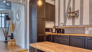 Una cocina moderna con armarios oscuros, encimera de madera y horno empotrado.