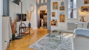Una sala de estar moderna con una mesa de centro de vidrio, piso de madera y una variedad de muebles, incluyendo un sofá y una silla.
