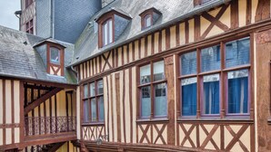 Un edificio tradicional con entramado de madera, múltiples ventanas y una escalera.