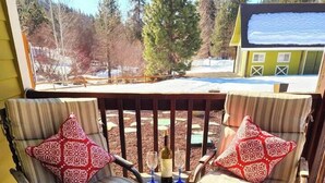 Eine Terrasse mit zwei Stühlen und einer Feuerstelle.