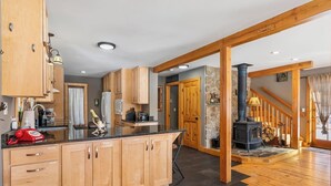 Eine moderne Küche mit Holzschränken, einer zentralen Kochinsel und einer Steinwand.