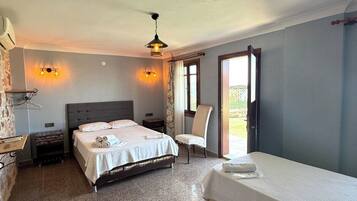 A hotel room with a bed, a chair, a desk, and a window.
